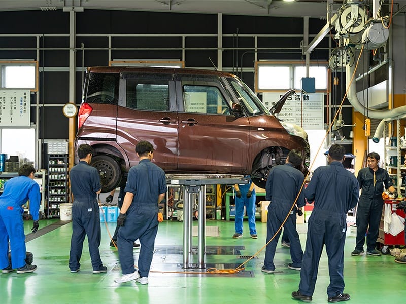 リフト上で車検作業を行っている車両の写真